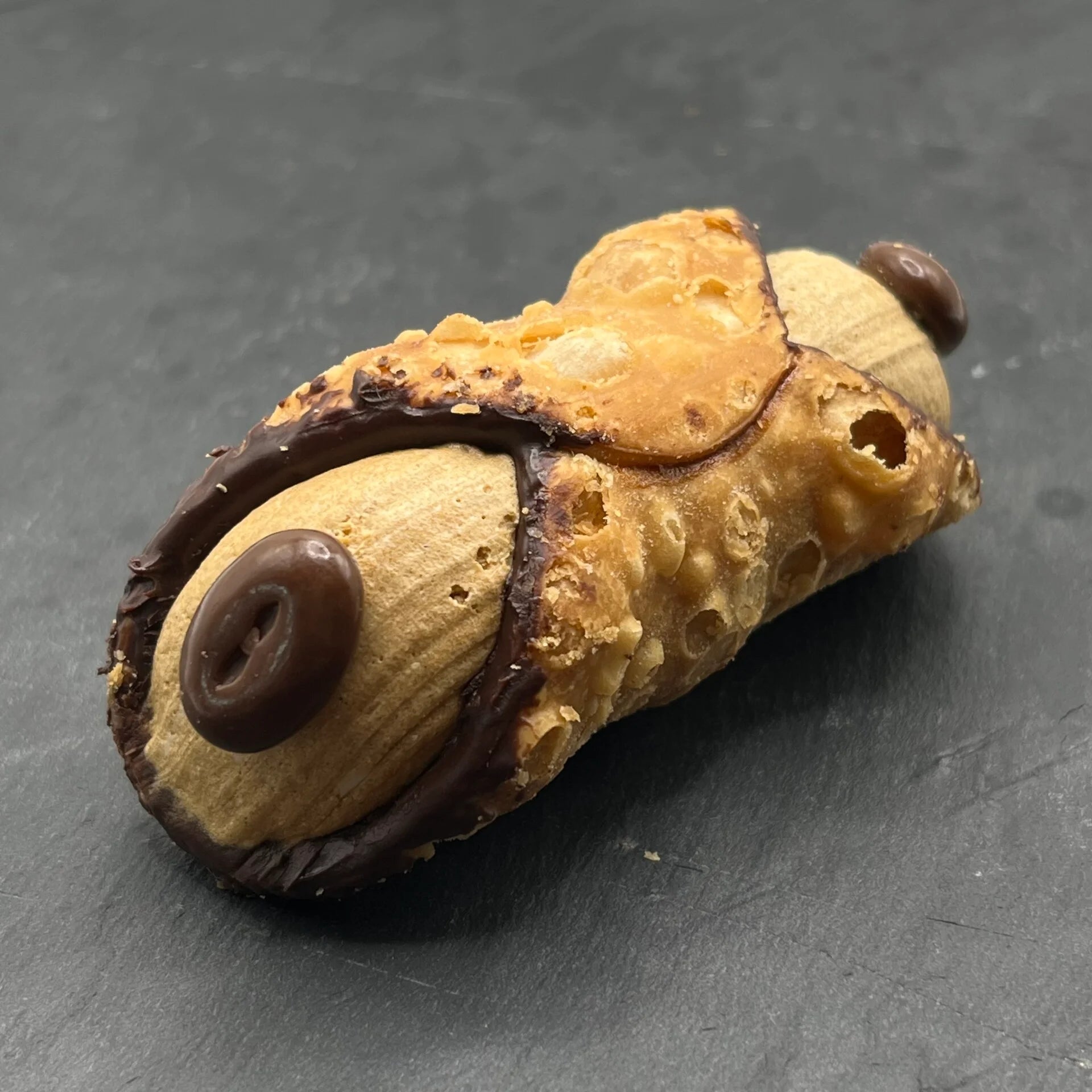 Geniet van de heerlijke Cannoli Caffè - Koffie, een traditioneel Siciliaans gebakje gevuld met romige koffie-vulling, perfect voor bij je kopje koffie.